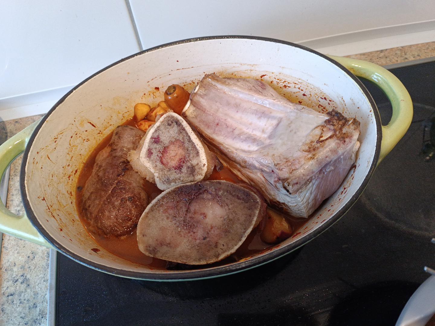 Rinderknochen, Rindfleisch und Schweinerippe im rotbraunen zweiten Fondansatz